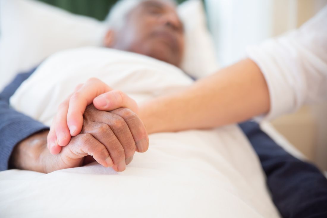 Mãos de uma pessoa jovem segurando as mãos de uma pessoa idosa